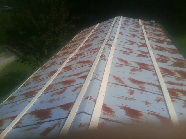 Rusted metal roof panels with new wood purlins before replacement — Storm Damage Roof Repair in Cedar by Roofing Brothers